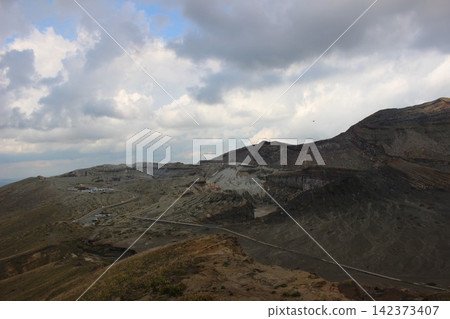 A breathtaking view of Senrigahama, a sandy beach of black volcanic ash near the Nakadake crater of Mount Aso in Kumamoto Prefecture, against a clear blue sky. A breathtaking view of Senrigahama, a sandy beach of black volcanic ash near the Nakadake crater of Mount Aso in Kumamoto Prefecture, against a clear blue sky. 142373407