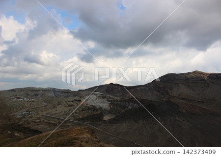 在晴朗的藍天下,熊本縣阿蘇山中岳火山口附近的黑色火山灰沙灘-千里濱,景色令人嘆為觀止。 在晴朗的藍天下,熊本縣阿蘇山中岳火山口附近的黑色火山灰沙灘-千里濱,景色令人嘆為觀止。 142373409