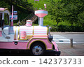 A side view of the pink and white train-shaped road train that tours the tourist facilities. 142373733