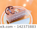 A close-up of an elegant cake made with layers of chocolate cream and sponge cake. 142373883