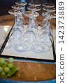 The neatly arranged clear stemmed glasses evoke the image of preparing a restaurant or hotel. 142373889