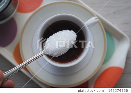 Coffee cup with sugar on spoon ready to mix Coffee cup with sugar on spoon ready to mix 142374566