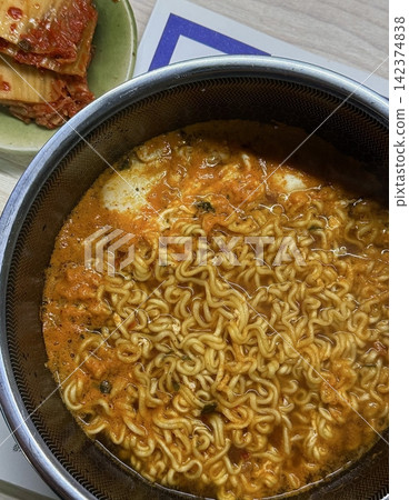 A steaming bowl of ramyeon with chewy noodles, rich and spicy broth, and flavorful toppings like green onions, egg, and vegetables. A quick and satisfying comfort food favorite. A steaming bowl of ramyeon with chewy noodles, rich and spicy broth, and flavorful toppings like green onions, egg, and vegetables. A quick and satisfying comfort food favorite. 142374838