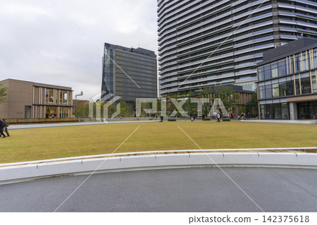 Tokyo, Japan - Nov 21,2024 : People resting on the lawn of the japan sport olympic square, Hope Square in Tokyo, Japan on Nov 21,2024. Tokyo, Japan - Nov 21,2024 : People resting on the lawn of the japan sport olympic square, Hope Square in Tokyo, Japan on Nov 21,2024. 142375618