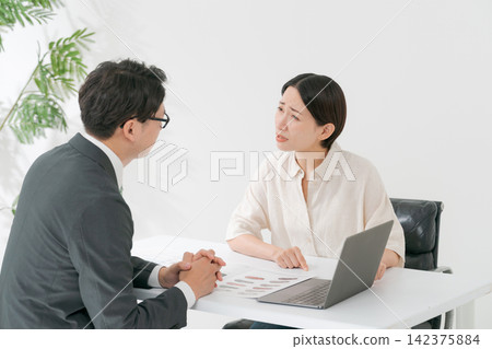 一位女顧客對一位穿西裝的男士感到生氣。 一位女顧客對一位穿西裝的男士感到生氣。 142375884