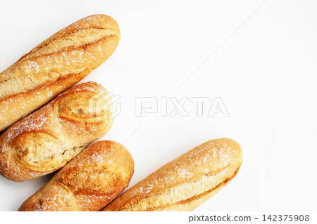 Freshly baked French baguettes arranged on a clean white background with large copy space Freshly baked French baguettes arranged on a clean white background with large copy space 142375908