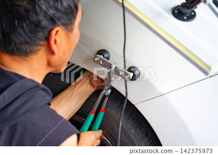 Removing dents on the car. PDR technology. Car body repair without painting. Removing dents on the car. PDR technology. Car body repair without painting. 142375973