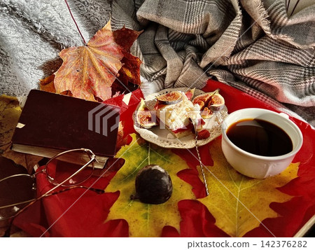 Cozy Autumn Flatlay with Coffee, Meringue Fig Dessert, Book, and Autumn Leaves Cozy Autumn Flatlay with Coffee, Meringue Fig Dessert, Book, and Autumn Leaves 142376282