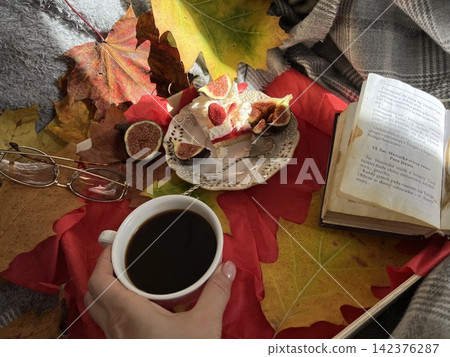Cozy Autumn Flatlay with Coffee, Meringue Fig Dessert, Book, and Autumn Leaves Cozy Autumn Flatlay with Coffee, Meringue Fig Dessert, Book, and Autumn Leaves 142376287