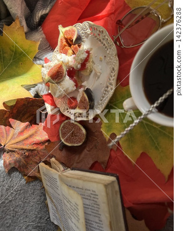 Cozy Autumn Flatlay with Coffee, Meringue Fig Dessert, Book, and Autumn Leaves Cozy Autumn Flatlay with Coffee, Meringue Fig Dessert, Book, and Autumn Leaves 142376288