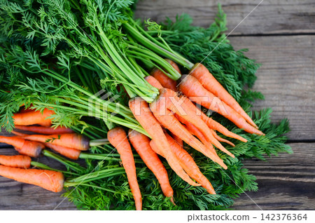 carrot on wooden table background, Fresh and sweet carrots for cooking food fruits and vegetables for health concept, baby carrots bunch and leaf carrot on wooden table background, Fresh and sweet carrots for cooking food fruits and vegetables for health concept, baby carrots bunch and leaf 142376364