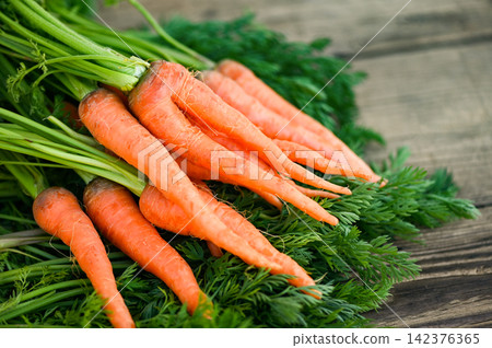 carrot on wooden table background, Fresh and sweet carrots for cooking food fruits and vegetables for health concept, baby carrots bunch and leaf carrot on wooden table background, Fresh and sweet carrots for cooking food fruits and vegetables for health concept, baby carrots bunch and leaf 142376365