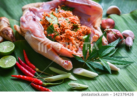 Cannabis food for cooking with fresh chicken cannabis leaf marijuana vegetables herbs and spices ingredients on banana leaf background, raw chicken hemp leaf plant THC CBD herbs - Thai food Cannabis food for cooking with fresh chicken cannabis leaf marijuana vegetables herbs and spices ingredients on banana leaf background, raw chicken hemp leaf plant THC CBD herbs - Thai food 142376426