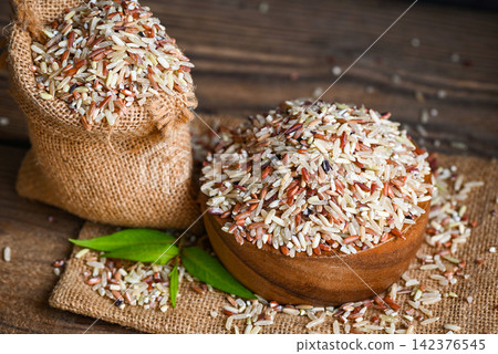 brown rice on wooden bowl and the sack background , raw various rice color mixed thai rice for cooking food , Loonzain rice brown black red white purple health food. brown rice on wooden bowl and the sack background , raw various rice color mixed thai rice for cooking food , Loonzain rice brown black red white purple health food. 142376545