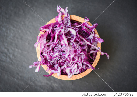 Cabbage purple / Shredded red cabbage slice in a wooden bowl and dark background Cabbage purple / Shredded red cabbage slice in a wooden bowl and dark background 142376582