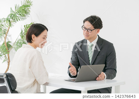 一名男子正在解釋,旁邊是一位女顧客。 一名男子正在解釋,旁邊是一位女顧客。 142376643