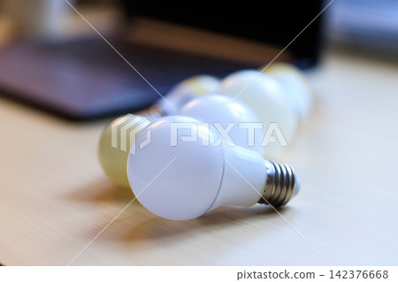 LED Light Bulbs on Wooden Table with Soft Focus Background LED Light Bulbs on Wooden Table with Soft Focus Background 142376668