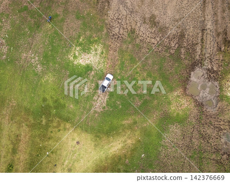 Aerial View of Pickup Truck on Muddy Rural Terrain Aerial View of Pickup Truck on Muddy Rural Terrain 142376669