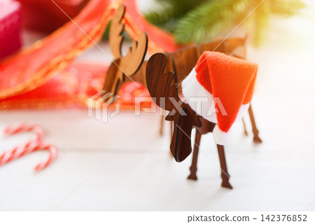 Christmas hat holiday background and decorations on christmas antlers of a deer and festive Happy New Year Christmas hat holiday background and decorations on christmas antlers of a deer and festive Happy New Year 142376852
