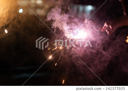 Children playing with handheld fireworks 142377035