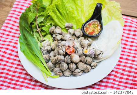 Cockle shellfish seafood plate with fresh vegetable herbs and spices on plate food Cockles background - blood cockle peeled on table with seafood sauce Cockle shellfish seafood plate with fresh vegetable herbs and spices on plate food Cockles background - blood cockle peeled on table with seafood sauce 142377042
