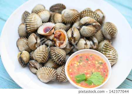 Cockles on white plate with seafood sauce on table background , Fresh raw shellfish blood cockle ocean gourmet seafood in the restaurant 142377044