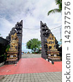 A beautiful traditional split gate and statues at Tanah Lot Temple, a famous tourist spot in Bali. 142377576