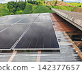 Solar Panels on Rural Rooftop with Green Agricultural Landscape 142377657