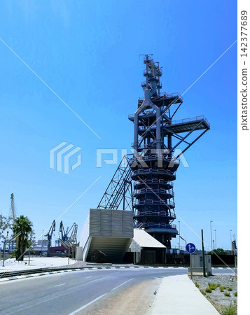 Industrial Steel Tower and Port Cranes Under Clear Blue Sky Industrial Steel Tower and Port Cranes Under Clear Blue Sky 142377689