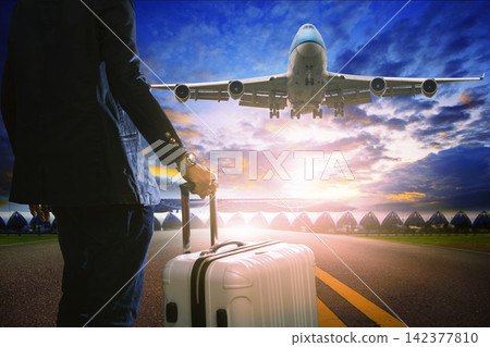Air Travel Passenger with Suitcase and Landing Jet at Sunset Air Travel Passenger with Suitcase and Landing Jet at Sunset 142377810