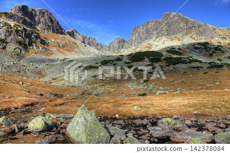 Rocky Alpine Mountain Landscape with Stream and Blue Sky Rocky Alpine Mountain Landscape with Stream and Blue Sky 142378084