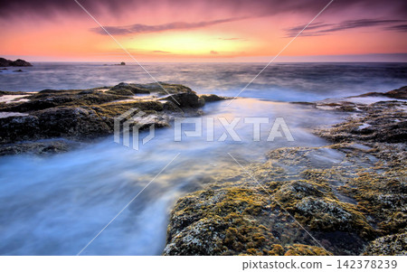 Rocky Ocean Coast at Sunset with Long Exposure Waves Rocky Ocean Coast at Sunset with Long Exposure Waves 142378239