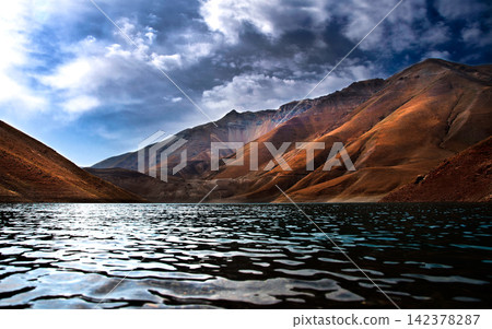 Mountain Lake Landscape with Dramatic Clouds and Rugged Peaks Mountain Lake Landscape with Dramatic Clouds and Rugged Peaks 142378287