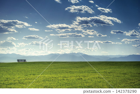 Scenic Meadow Landscape with Bench, Mountains and Blue Sky Scenic Meadow Landscape with Bench, Mountains and Blue Sky 142378290