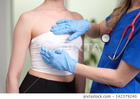 Oncologist mammologist palpating woman breast in search of tumor closeup Oncologist mammologist palpating woman breast in search of tumor closeup 142379240