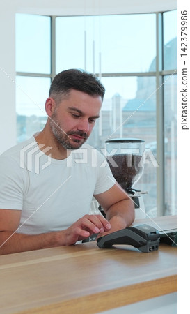 Vertical video. In the cafe man makes coffee for a customer which pay using credit card contactless payment spending money in cafe with digital transaction service. Vertical video. In the cafe man makes coffee for a customer which pay using credit card contactless payment spending money in cafe with digital transaction service. 142379986