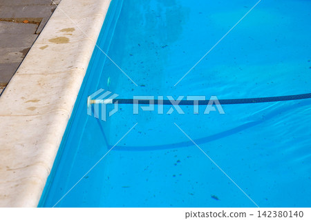 Cleaning of pool. Connection of corrugated hose under blue water Cleaning of pool. Connection of corrugated hose under blue water 142380140