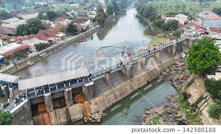 An aerial drone perspective reveals the historic Katulampa Dam spanning the Ciliwung River in Bogor at summer time 142380188