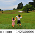 A brother and sister flying model airplanes 142380660