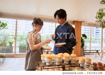 一對夫婦在飯店自助餐廳取餐。 一對夫婦在飯店自助餐廳取餐。 142381106