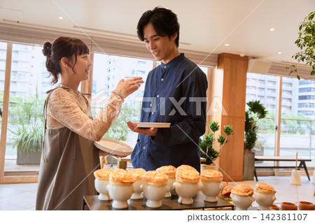 一對笑容滿面的夫婦在餐廳自助餐上享用派。 一對笑容滿面的夫婦在餐廳自助餐上享用派。 142381107
