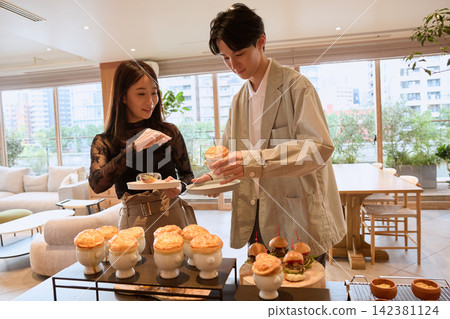 一對年輕夫婦在時尚咖啡館享用自助餐。 一對年輕夫婦在時尚咖啡館享用自助餐。 142381124