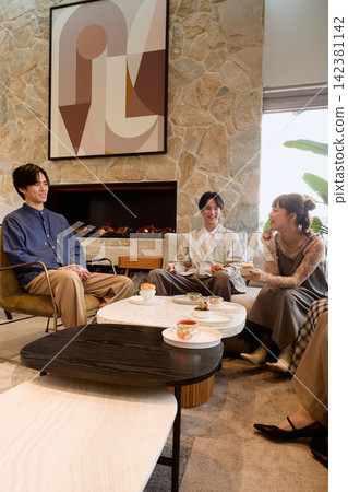 A group of three young male friends enjoying a meal at a stylish cafe. A group of three young male friends enjoying a meal at a stylish cafe. 142381142