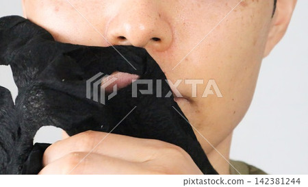 A person peeling off a face mask A person peeling off a face mask 142381244