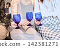 三位女士舉著藍色酒杯碰杯。 142381271
