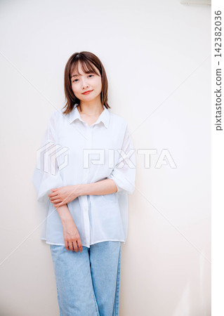 一位年輕女子在室內微笑。 一位年輕女子在室內微笑。 142382036
