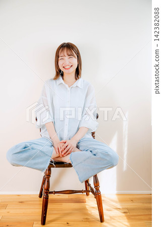 A woman sitting in a chair and smiling. A woman sitting in a chair and smiling. 142382088