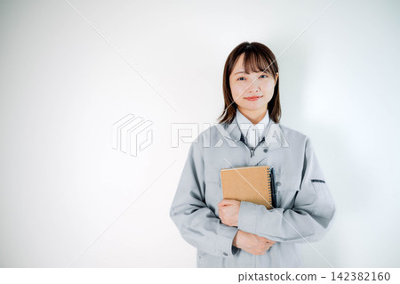 Female staff in work clothes during on-site work Female staff in work clothes during on-site work 142382160