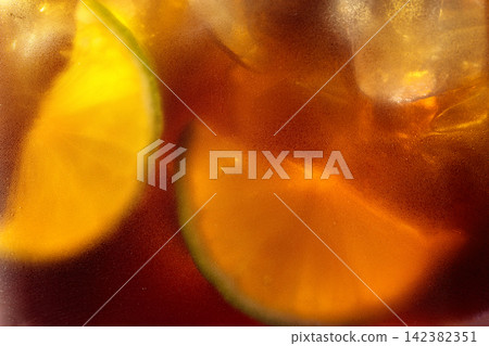 Refreshing cocktail with lime, cola and ice in a misted glass. Refreshing cocktail with lime, cola and ice in a misted glass. 142382351