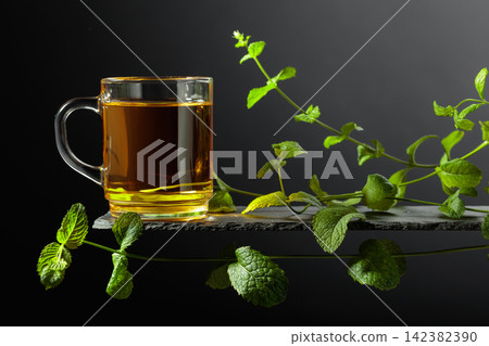 Cup of mint tea and fresh mint sprigs. Cup of mint tea and fresh mint sprigs. 142382390
